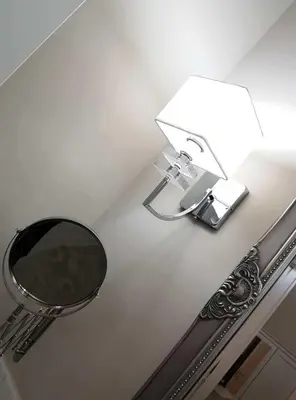 a bathroom with a mirror and a light on a wall at Casa De Rose in Rome