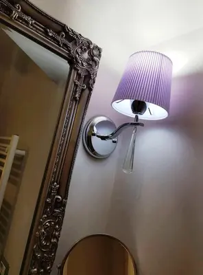 a lamp on a wall next to a mirror at Casa De Rose in Rome