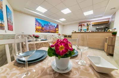 a dining room with a table with a flower on it at Hotel Balilla in Rome