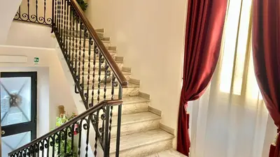 a staircase in a home with a red curtain at Hotel Balilla in Rome
