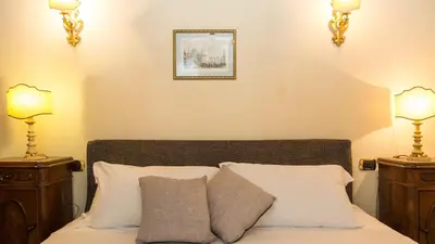 a bedroom with a bed with two night stands and two lamps at Rental in Rome Falegnami in Rome