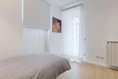 a white bedroom with a bed and a window at Lovely 3 rooms apartment close Trastevere Station in Rome