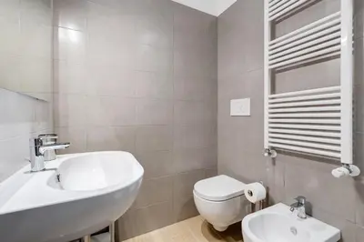 a white bathroom with a sink and a toilet at Lovely 3 rooms apartment close Trastevere Station in Rome