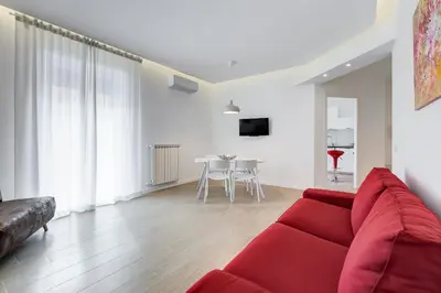 a living room with a red couch and a table at Lovely 3 rooms apartment close Trastevere Station in Rome