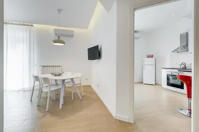 a white kitchen and dining room with a table and chairs at Lovely 3 rooms apartment close Trastevere Station in Rome