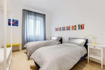 two beds in a room with white walls at Lovely 3 rooms apartment close Trastevere Station in Rome