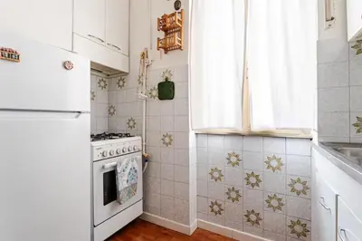 a white kitchen with a stove and a window at Casa della Salita San Pietro in Rome