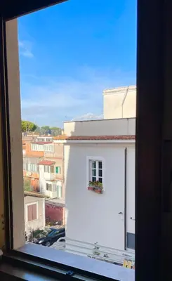 a window view of a white building with a flower box at Casa della Salita San Pietro in Rome