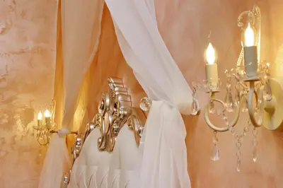 a wedding dress hanging on a wall with candles at Deluxe rooms and One Chilling jacuzzi Suite Guesthouse in Rome