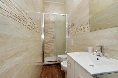 a bathroom with a toilet and a sink and a shower at Deluxe rooms and One Chilling jacuzzi Suite Guesthouse in Rome