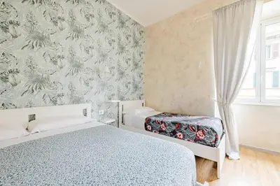 a bedroom with two beds and a floral wallpaper at Deluxe rooms and One Chilling jacuzzi Suite Guesthouse in Rome