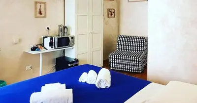 a room with a blue bed and a microwave at Deluxe rooms and One Chilling jacuzzi Suite Guesthouse in Rome