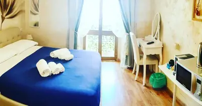 a bedroom with a blue bed with towels on it at Deluxe rooms and One Chilling jacuzzi Suite Guesthouse in Rome