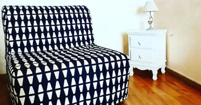 a black and white chair in a room with a nightstand at Deluxe rooms and One Chilling jacuzzi Suite Guesthouse in Rome