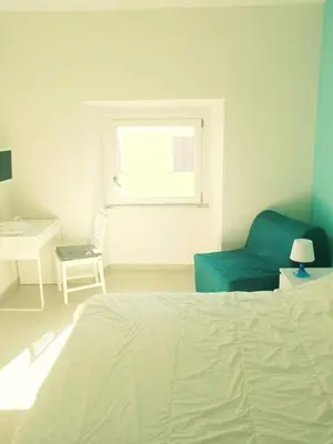 a bedroom with a bed and a chair and a window at Roma TouristHome via palestro 56 in Rome