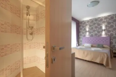 a bathroom with a shower and a bed in a room at Rome Kings Suite in Rome
