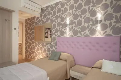 a bedroom with two beds and a purple wall at Rome Kings Suite in Rome