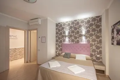 a bedroom with a large bed with a pink headboard at Rome Kings Suite in Rome