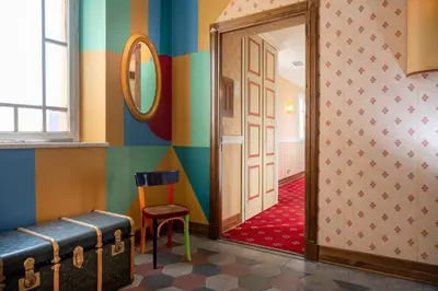 a hallway with a mirror and a stool in a room at Hotel Oceania in Rome