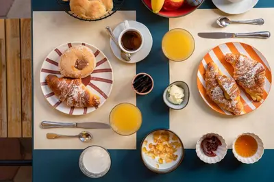 a table with plates of pastries and cups of orange juice at Hotel Oceania in Rome