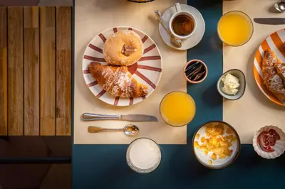 a table topped with plates of food and orange juice at Hotel Oceania in Rome