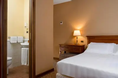 a bedroom with a bed and a bathroom with a toilet at Hotel Oceania in Rome