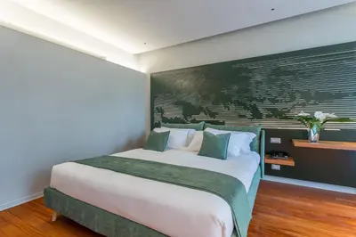 a bedroom with a large bed with a green accent wall at Fauno Urban Resort in Rome