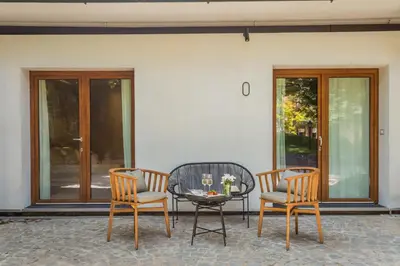 a patio with two chairs and a table with a glass table at Fauno Urban Resort in Rome