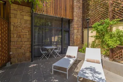 a patio with two chairs and a table at Fauno Urban Resort in Rome