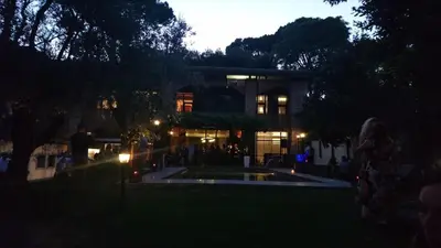 a night view of a building with a fountain in the yard at Fauno Urban Resort in Rome