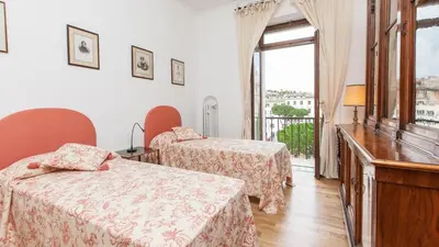a hotel room with two beds and a balcony at Rental In Rome Ancient View in Rome
