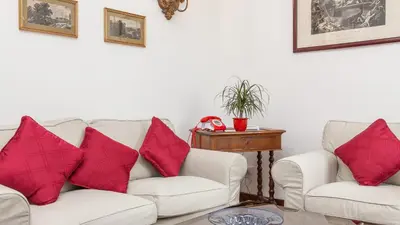a living room with two white couches and red pillows at Rental In Rome Ancient View in Rome
