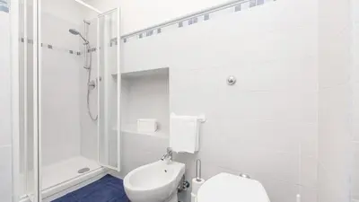 a white bathroom with a toilet and a shower at Rental In Rome Ancient View in Rome