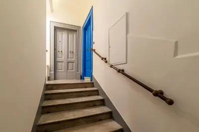 a stairway with a blue door and stairs at GuestHost - Sallustiano Apartments in Rome
