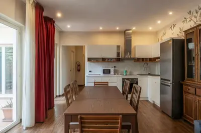 a kitchen with a table and chairs and a refrigerator at GuestHost - Sallustiano Apartments in Rome