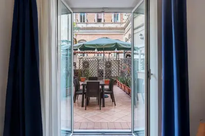 a balcony with a table with chairs and an umbrella at GuestHost - Sallustiano Apartments in Rome