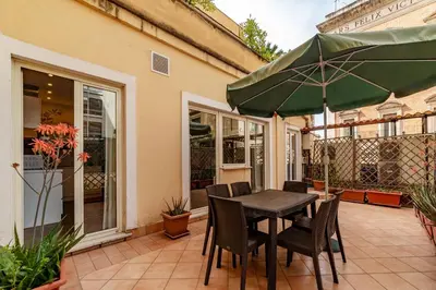 a patio with a table and chairs and an umbrella at GuestHost - Sallustiano Apartments in Rome