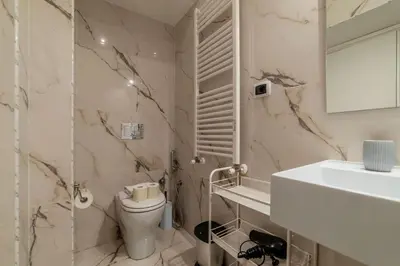 a white bathroom with a toilet and a sink at GuestHost - Sallustiano Apartments in Rome