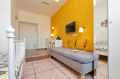 a living room with a couch and a yellow wall at Domus Ponte Milvio in Rome