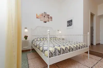 a bedroom with a white bed with a white bedspread at Domus Ponte Milvio in Rome