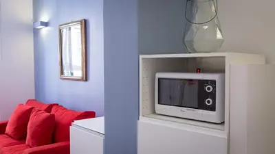 a living room with a red couch and a microwave at Rental in Rome Beato Angelico in Rome