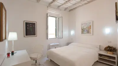 a white bedroom with a bed and a desk and a chair at Rental in Rome Beato Angelico in Rome