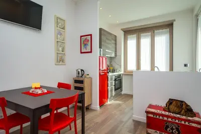 a kitchen and dining room with a table and red chairs at Many Days Apartments in Rome