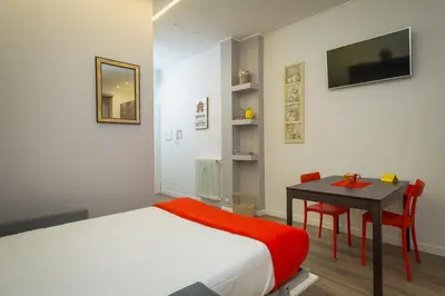 a bedroom with a bed and a table with a desk at Many Days Apartments in Rome