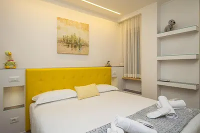 a bedroom with a bed and a yellow headboard at Many Days Apartments in Rome