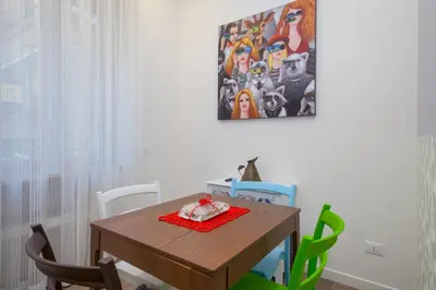 a dining room table with chairs and a painting on the wall at Many Days Apartments in Rome