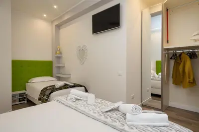 a bedroom with two beds and a tv on the wall at Many Days Apartments in Rome