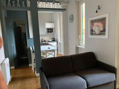 a living room with a couch and a kitchen at La Casetta del Flaminio a Roma Centro in Rome