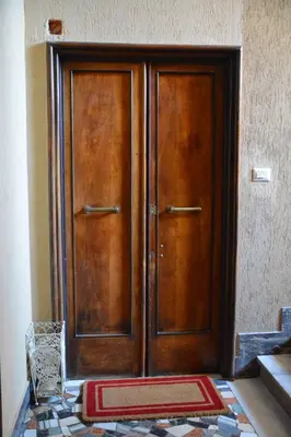 a wooden door with a rug in front of it at La Casetta del Flaminio a Roma Centro in Rome