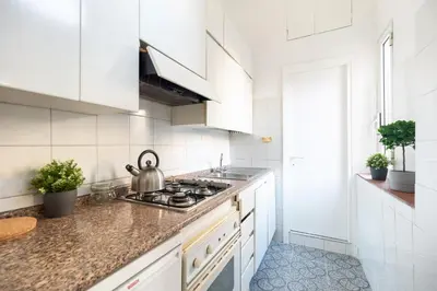a kitchen with white cabinets and a tea kettle on the stove at Cozy studio Campo de Fiori in Rome